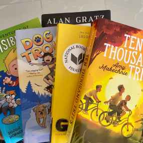 a selection of middle grade books with amy makechnie's ten thousand tries on top