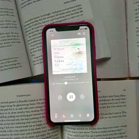 a phone laid on a book with the libro.fm audiobook app open
